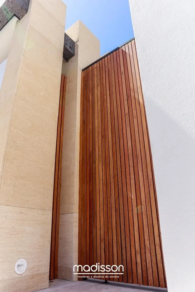 Puerta de entrada de gran formato en listones verticales de madera
