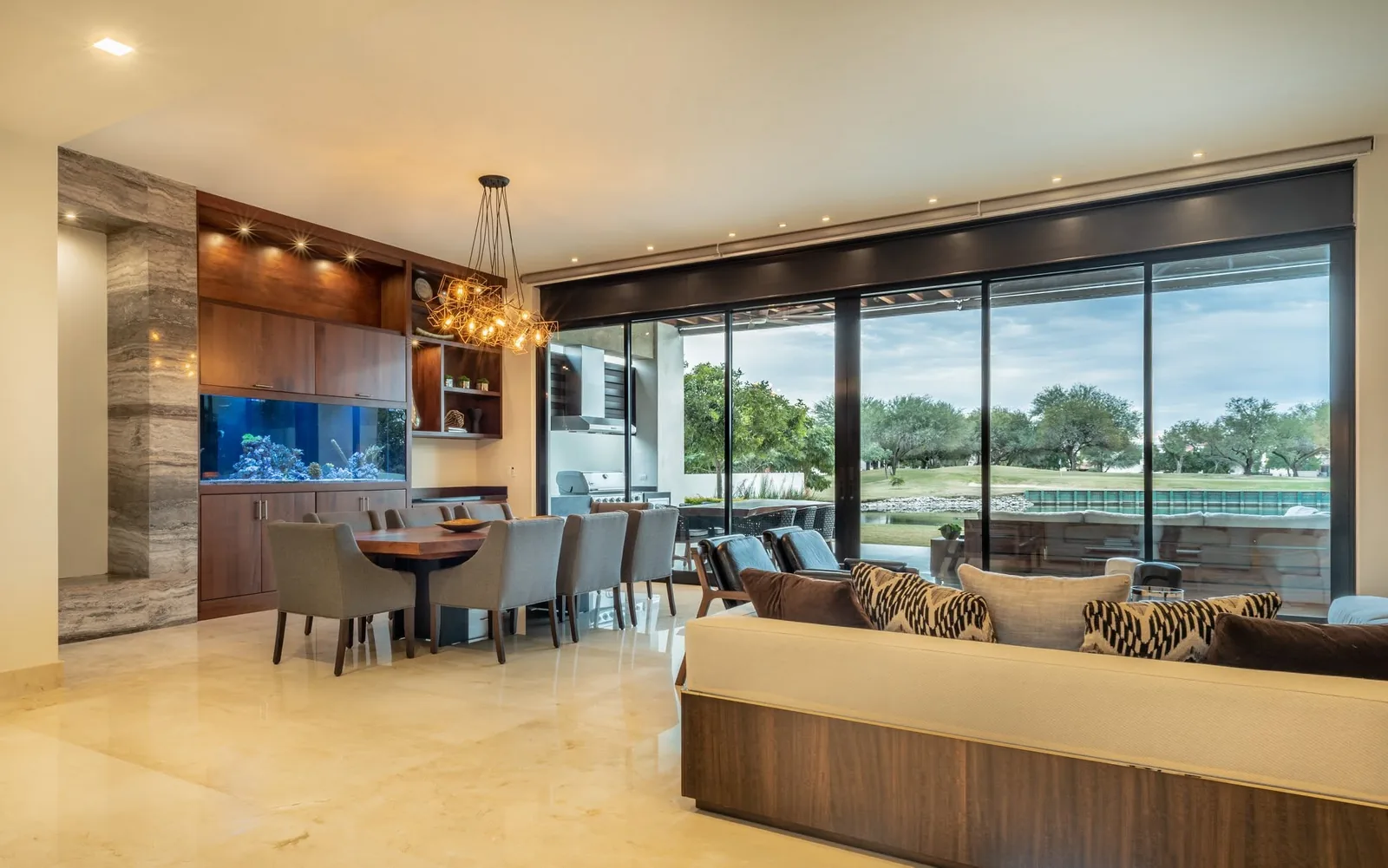 Sala y comedor con centro de entretenimiento de nogal y vista al campo de golf